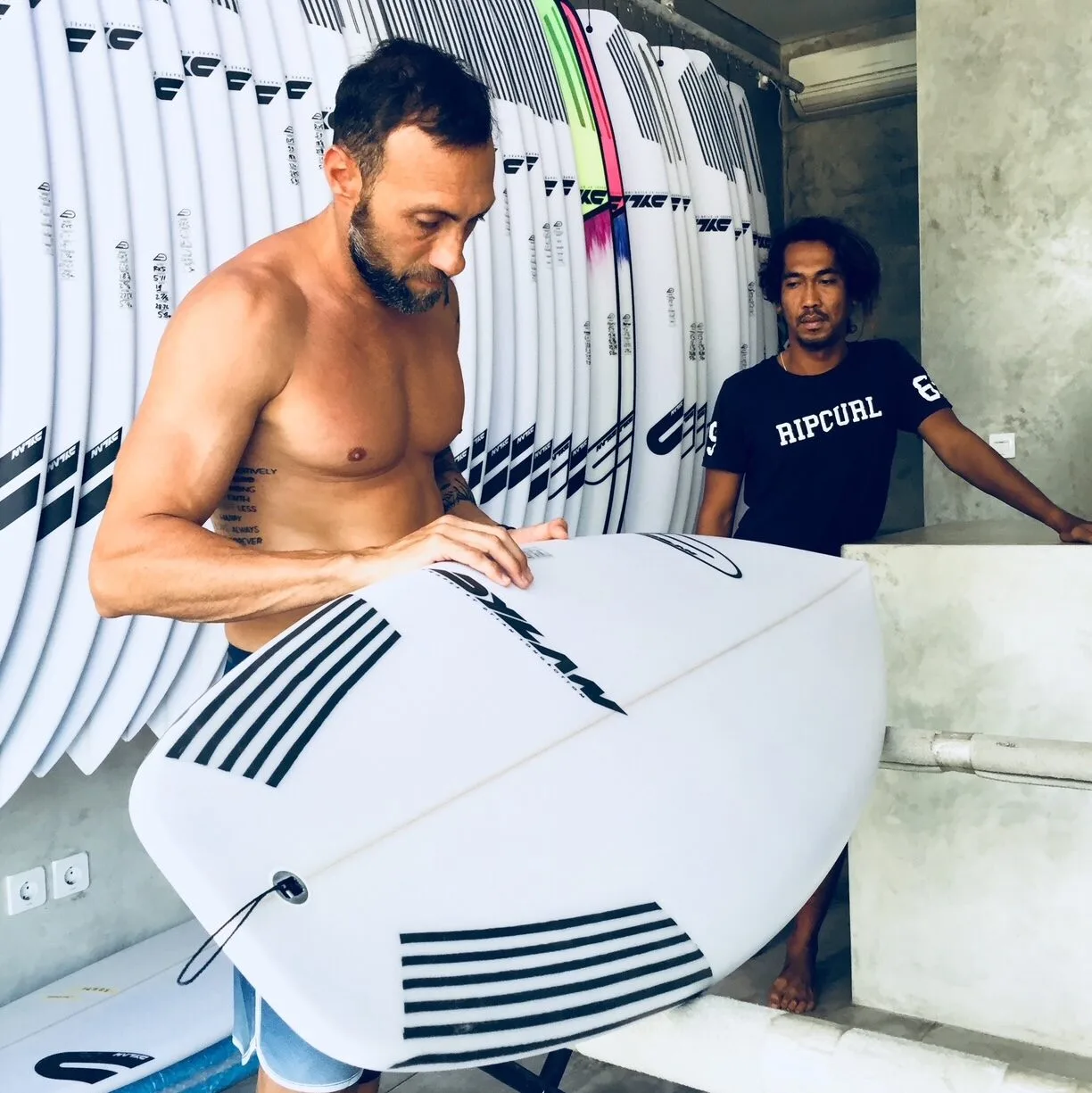 Surfer change surf board at surfshop