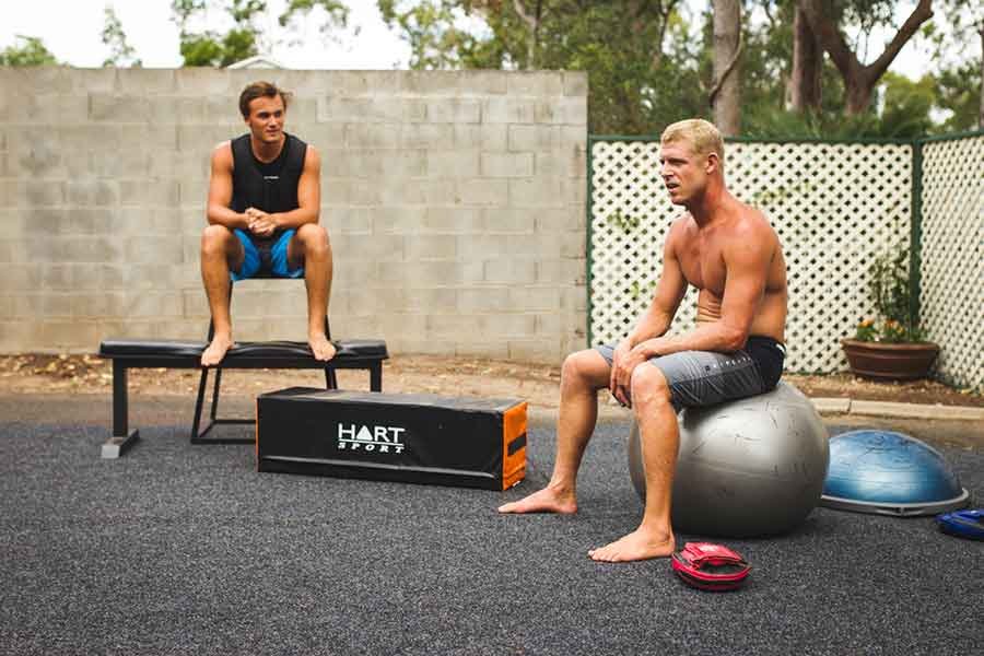 Two surfers training with a medicine ball to Progress in Surfing