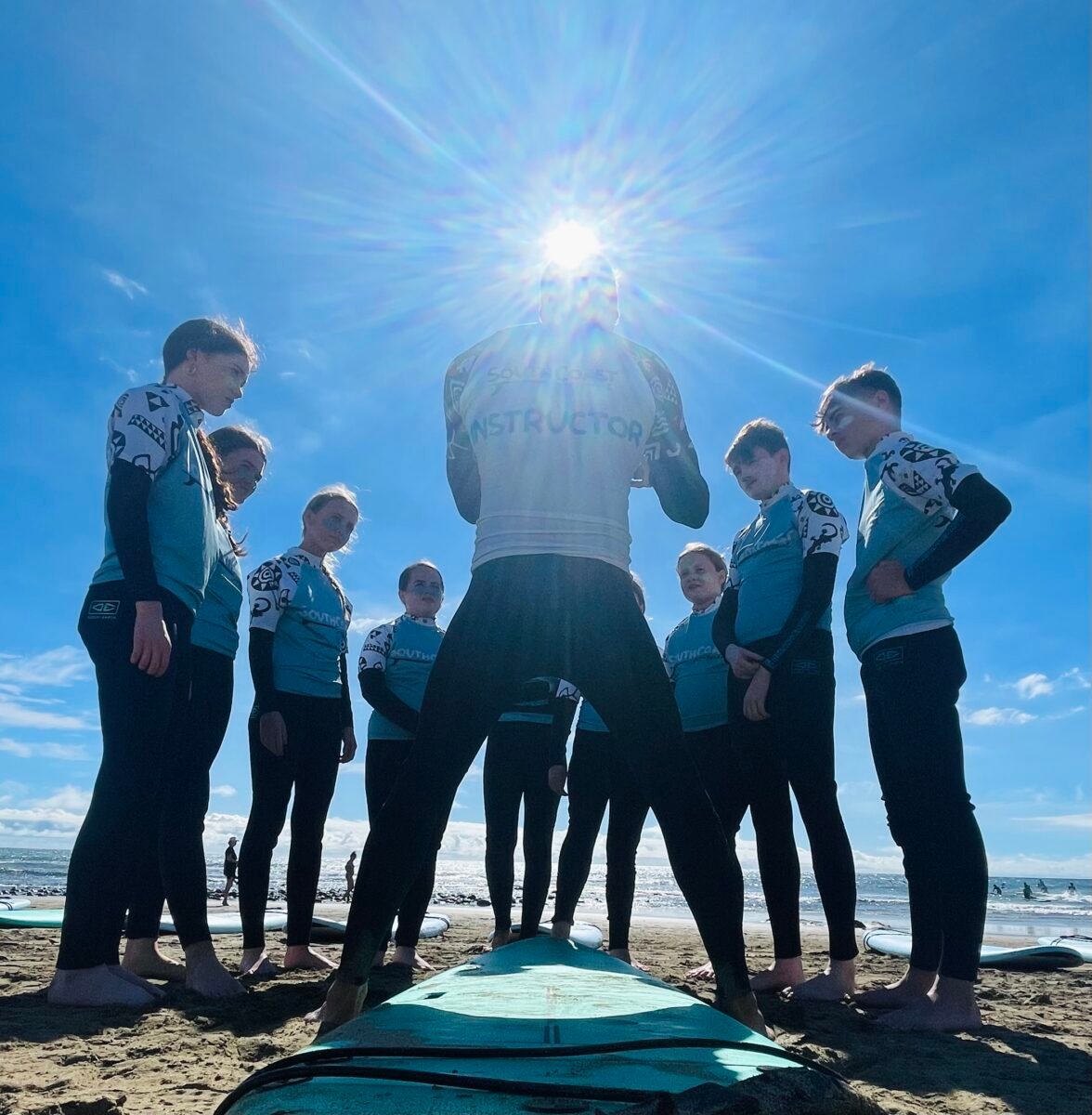 Group of surf beginners with the instructor to progress in surfing